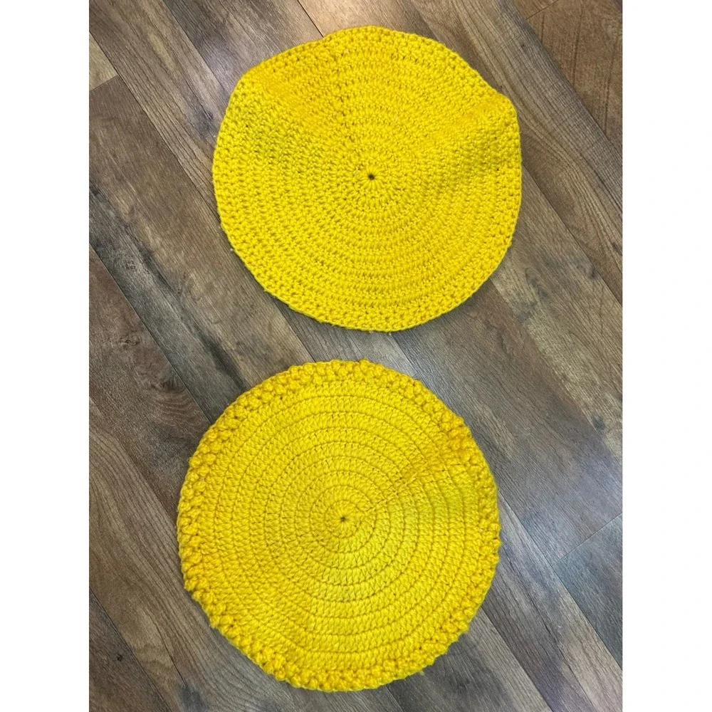 Two yellow crocheted placemats